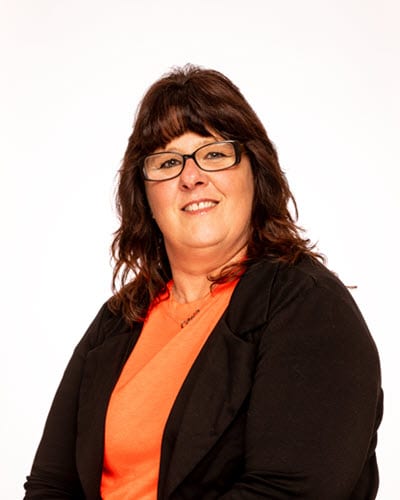 Woman with glasses smiling against a white background.